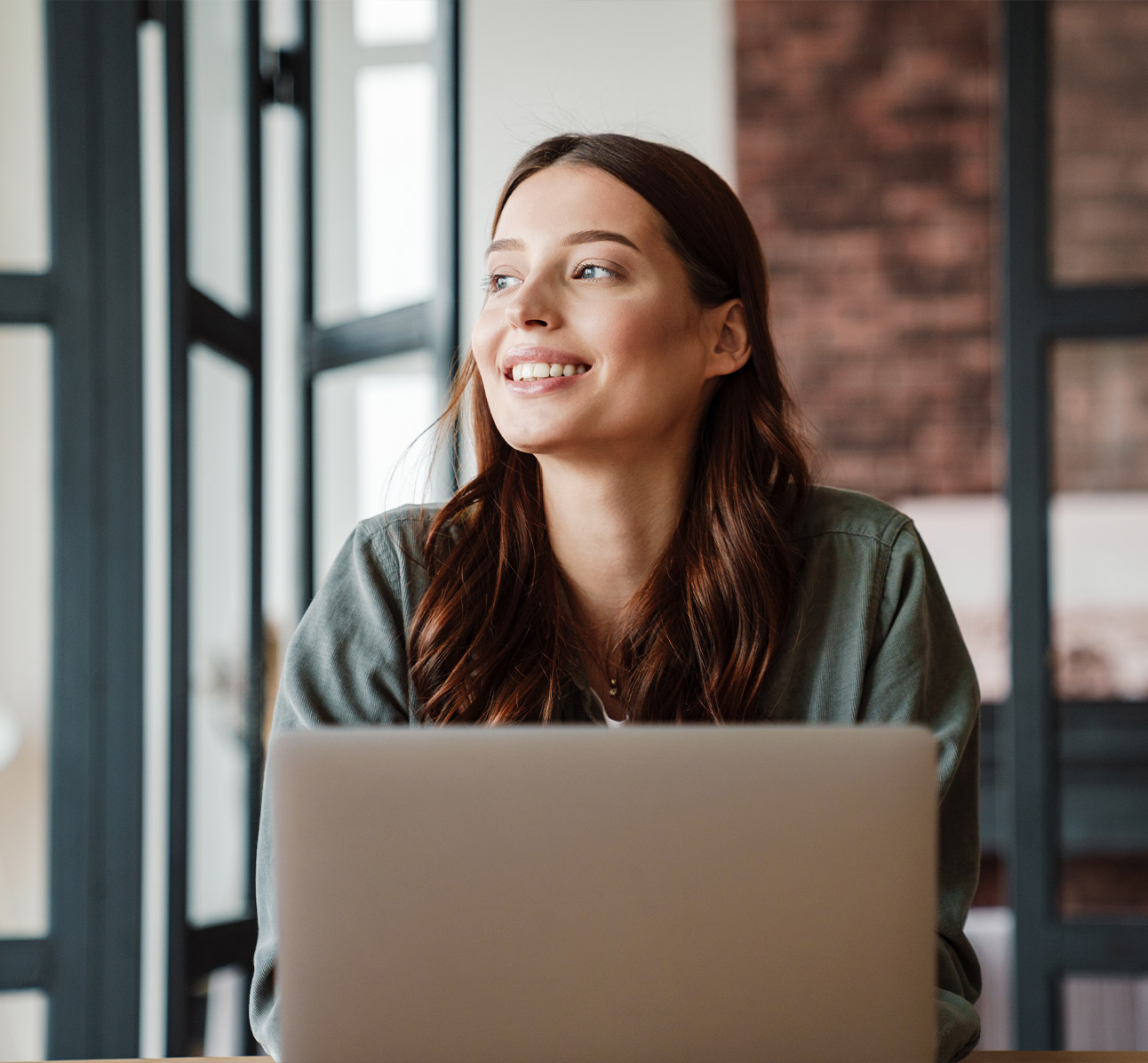Lachende jong professional voor een laptopscherm